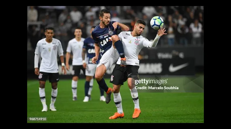Cầu thủ Santos chuyền bóng chính xác qua đối thủ Corinthians trong trận đấu